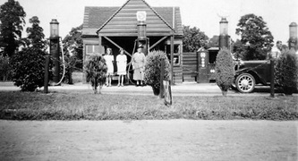 Historic photo of a building with people stood outside